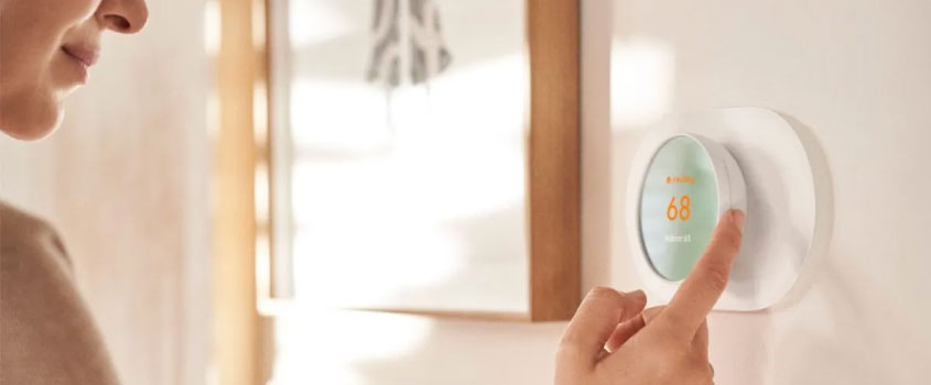 Woman adjusting thermostat